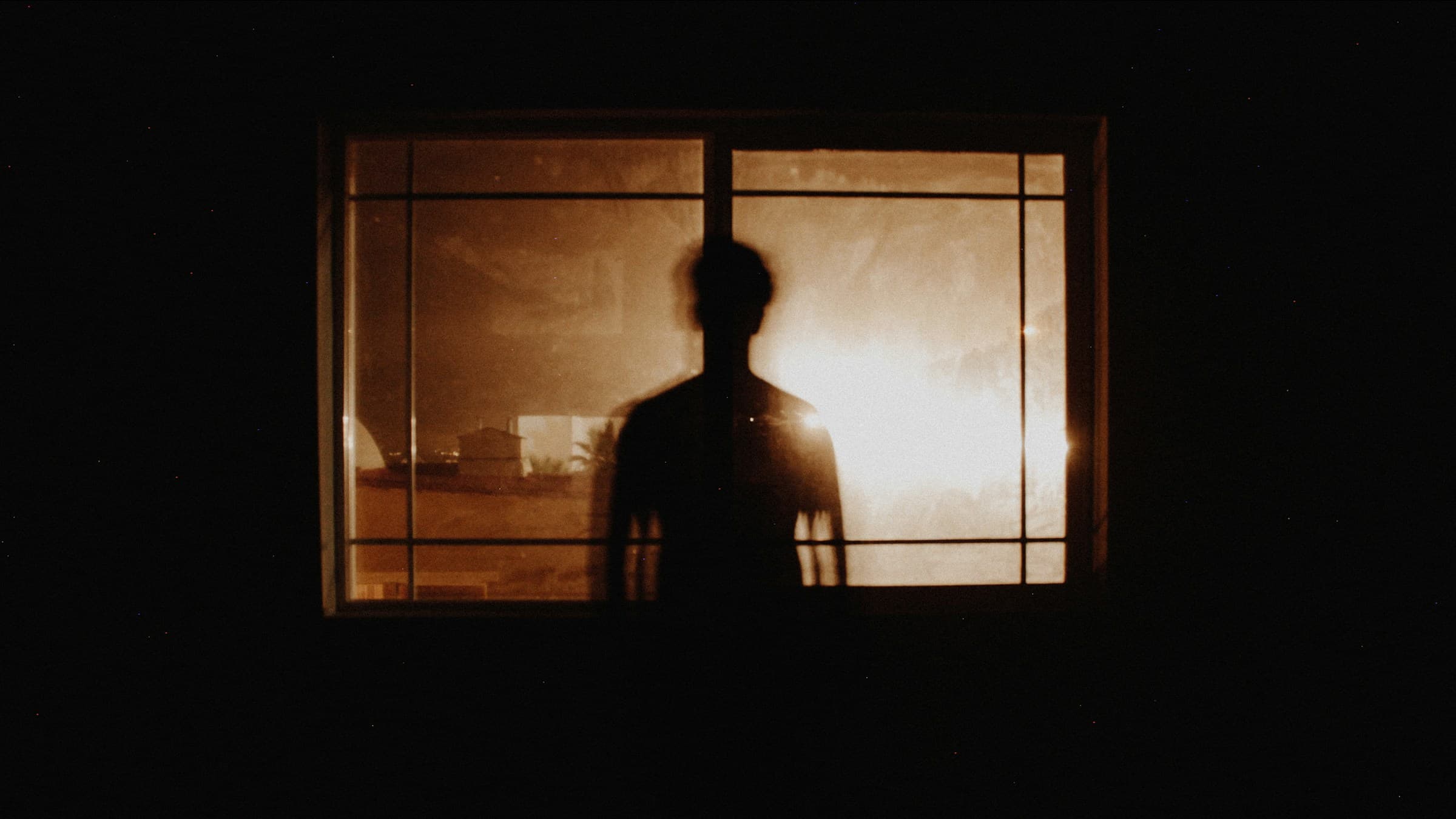Solitary figure silhouette in front of a sunlit window. Photo by Isai Ramos on Unsplash.